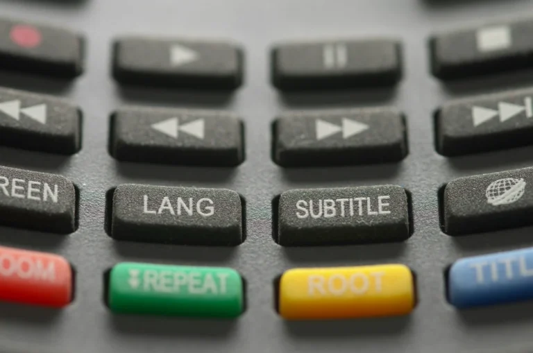 close-up of computer console buttons labled "Lang" "subtitle" etc, along with fastforward, play and pause buttons.